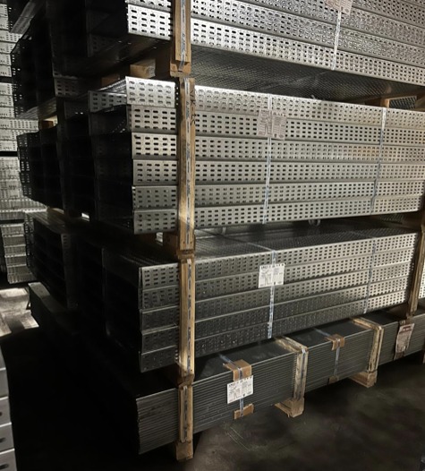 Stacks of galvanised cable trays in a warehouse
