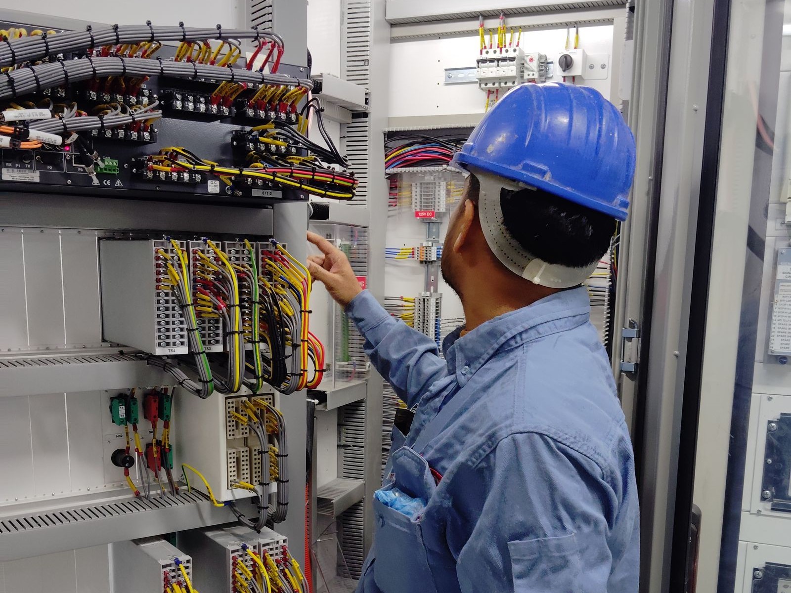 Technician inspecting a telecom equipment control panel